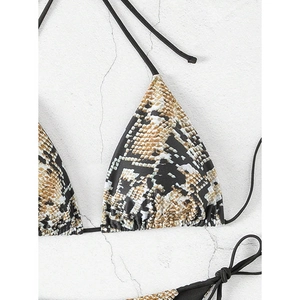 Macro detail of snake print bikini top featuring adjustable black ties and triangle cups
