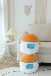Detail of stacked astronaut potato plush toys on a beige sofa in a cozy home setting