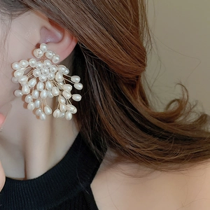 Detailed view of handmade baroque pearl flower earrings with intricate gold wire weave