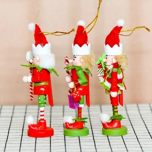 Set of three 13cm wooden Christmas nutcracker elf ornaments with festive red and green outfits