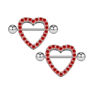 Detailed view of silver heart-shaped nipple shields with red gemstones and barbells