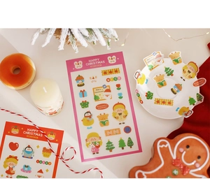 Close-up of Christmas stickers featuring Santa, reindeer, and festive icons on a plate