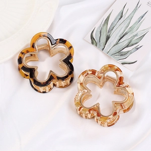 Close-up of tortoise shell flower hair claws in dark brown and light amber resin