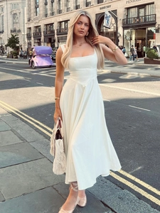 Détail de la robe longue blanche à col carré avec taille ajustée et jupe évasée