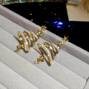 Macro view of gold-plated Christmas tree stud earrings with sparkling star and zircons