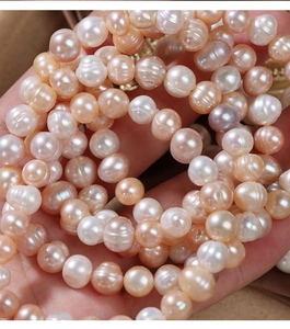 Macro detail of natural freshwater pearls in pink, cream, and champagne colors with gloss