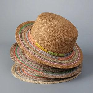Detail of three stacked boho straw hats with colorful striped brims and natural weave