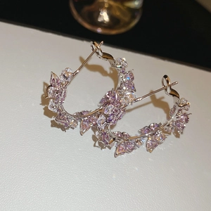Macro shot of silver-plated butterfly earrings with purple zircon crystals and butterfly design