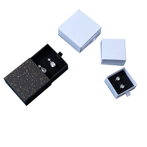 Drawer style jewelry boxes in black and white with gold accents and pull tabs