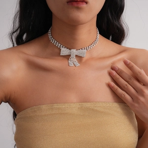 Close-up of a sparkling rhinestone bow choker necklace worn on a model for a luxury party look