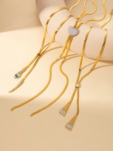 Détail de chaînes de serpent dorées avec breloques cœurs et pendentifs tête de serpent