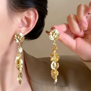 Detail of gold layered petal tassel earrings with vintage textured metal finish