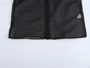 Detail of elegant black organza blouse showing sheer texture and front button closure
