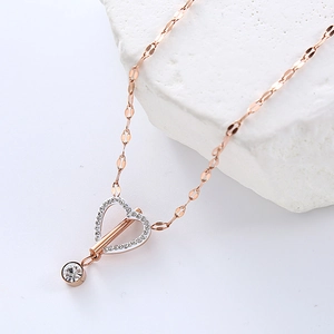 Rose gold heart pendant necklace with rhinestones and OT buckle on a minimalist stone