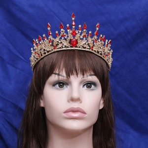 Close-up of Baroque gold crown with red teardrop rhinestones on a white mannequin head