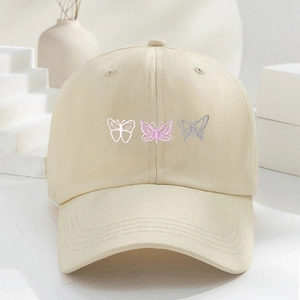 Beige cotton baseball cap featuring three butterfly embroidery details with curved brim