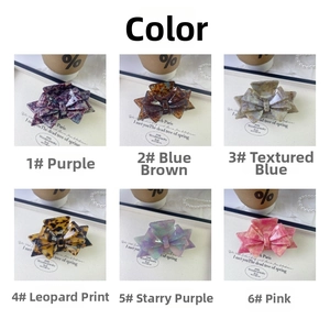 Flat lay of six acetate bow hair claws in various colors and textures with pearl decor