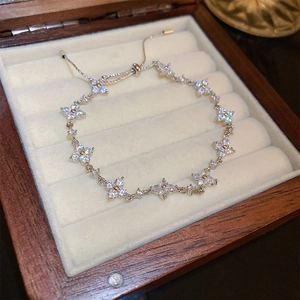Detailed shot of silver clover bracelet with white zircons in a premium jewelry box
