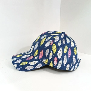 Detailed view of dark blue baseball cap with colorful ethnic feather print and curved brim