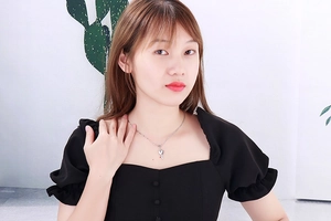 Close-up of a silver heart key pendant necklace worn by a model for elegant look