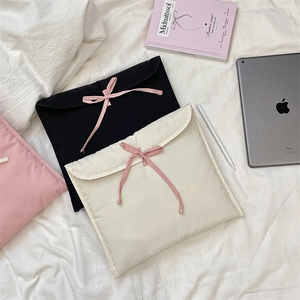 Dettaglio delle custodie imbottite per tablet con fiocchi in beige, nero e rosa