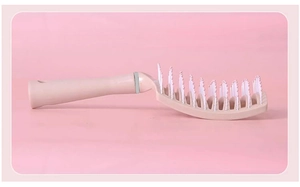 Nahaufnahme der rosa geschwungenen Skelettbürste mit ergonomischem Griff für Kopfmassage