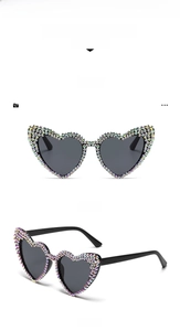 Detail of vintage heart-shaped sunglasses with colorful rhinestones and grey lenses