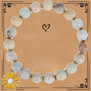 Pink zebra stone bracelet with sunflower charm displayed on a kraft paper gift card