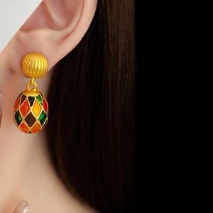 Vintage gold stripe stud earrings with multi-color enamel oval drop shown on a model