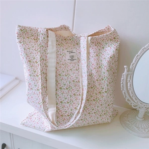 Detailaufnahme einer Vintage-Stofftasche mit Blumenmuster und Markenetikett