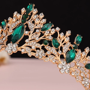 Close-up of Baroque crown featuring emerald green gems and gold floral metalwork