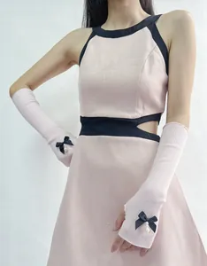 Detailed view of pink knitted sleeve with delicate black bow and pearl pendant decoration
