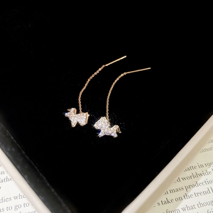 Detail of rose gold pony earrings with clear crystals on a black velvet jewelry box