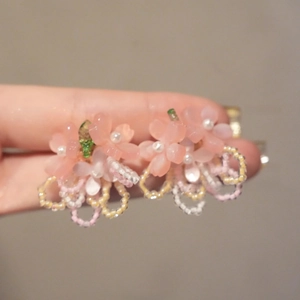 Detailed macro view of pink resin petal earrings with white pearl and handmade beads