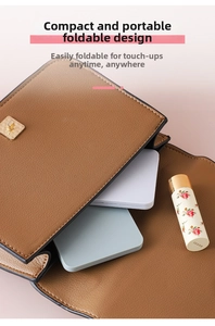 Minimalistischer quadratischer Klappspiegel, verstaut in einer braunen Handtasche