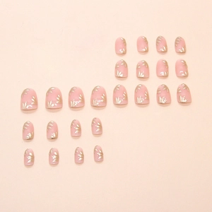 Short round press-on nails with pale pink base and golden bamboo leaf 3D patterns