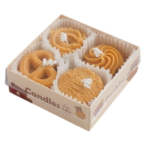 Set de cuatro velas aromáticas con forma de galleta en tono caramelo sobre fondo blanco