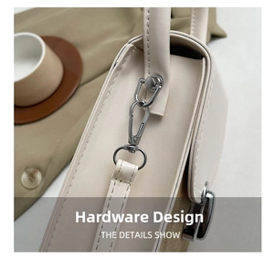 Close-up of the silver metal hook and strap connector on a chic two-tone leather bag