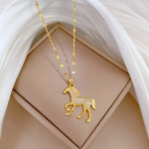Close-up of golden horse pendant with sparkling crystals on a flat curb chain link
