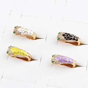 Detailed macro view of colorful enamel snake head earrings with sparkling zircon gemstones