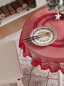 Detail of red Christmas lace tablecloth with hollow patterns and scalloped edges