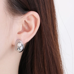Detail of 18K silver-plated earring featuring a lustrous white pearl in a curved frame
