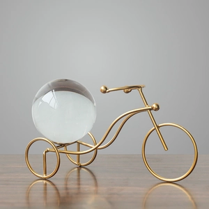Minimalist golden metal tricycle sculpture with clear crystal ball for home decor
