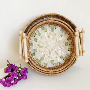 Detailed set of three nested woven trays with shell mosaic base and wooden handles