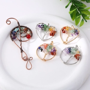 Handmade life tree crystal pendants in heart and round shapes on a white tray
