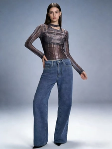 Pantalon large vieilli avec nœud et ceinture associé à un haut en résille imprimé chic