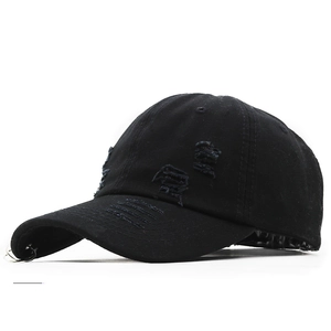 Détails d'une casquette noire délavée avec anneaux métalliques et effet déchiré