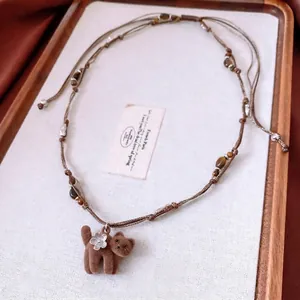 Collier en perles d'oeil de tigre avec pendentif chat en velours et détails argentés