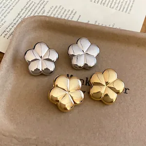 Minimalist metallic flower stud earrings with polished gold and silver mirror finish