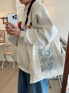 Minimalist canvas tote bag with light blue floral lace pocket for women's daily commute
